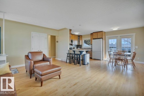 Open-concept living area with light wood-finish flooring - 10633 St Gabriel School Road, Edmonton, AB - Indoor