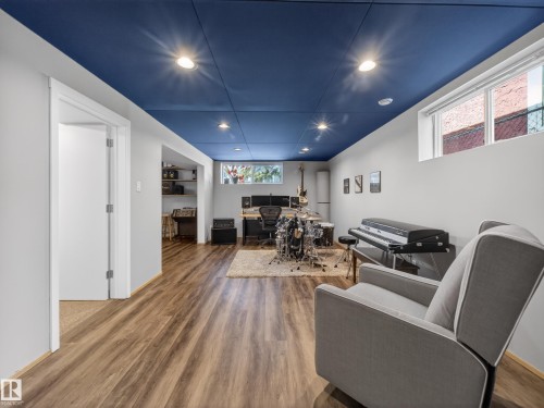 Finished lower level with wood-finish flooring, recessed lighting, and a blue ceiling - 11345 89 Street, Edmonton, AB - Indoor