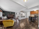 Open-concept living space featuring wood-finish flooring, a kitchen with stainless steel appliances, and wood cabinetry - 11345 89 Street, Edmonton, AB  - Indoor Photo Showing Living Room 