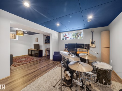 Versatile finished space featuring wood-finish flooring, recessed lighting, and a blue ceiling treatment - 11345 89 Street, Edmonton, AB - Indoor Photo Showing Other Room