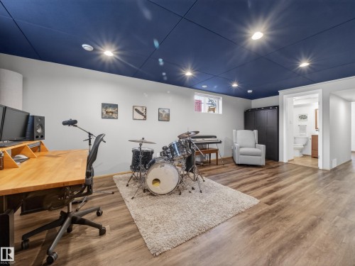 Spacious room featuring wood-finish flooring, a recessed lighting system, and a deep blue ceiling - 11345 89 Street, Edmonton, AB - Indoor