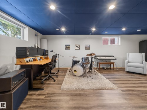 Dedicated studio space featuring a custom wood-finish desk, recessed ceiling lighting, wood-finish flooring, and a sound-dampening ceiling - 11345 89 Street, Edmonton, AB - Indoor