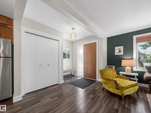 Entryway featuring wood-finish flooring, a solid core entry door, bi-fold closet doors, and recessed lighting - 11345 89 Street, Edmonton, AB - Indoor