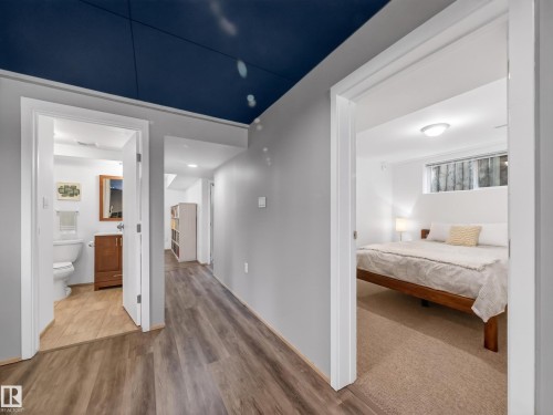 Hallway featuring wood-finish flooring, light gray walls, and a dark blue ceiling - 11345 89 Street, Edmonton, AB - Indoor