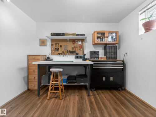 Versatile workspace featuring wood-finish flooring and a window providing natural light - 11345 89 Street, Edmonton, AB - Indoor Photo Showing Office