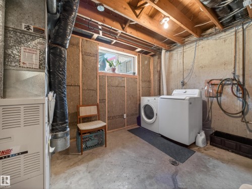 Dedicated utility area featuring a furnace, washer, dryer, and exposed wood ceiling beams - 11345 89 Street, Edmonton, AB - Indoor Photo Showing Laundry Room