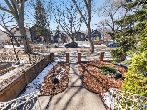 Front yard, concrete pathway leading to a brick pillar entrance with a decorative metal gate - 11345 89 Street, Edmonton, AB - Outdoor