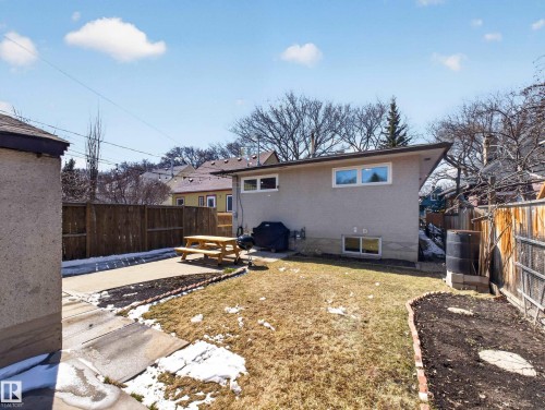 Backyard space featuring a concrete patio, wood fencing, and a stucco exterior - 11345 89 Street, Edmonton, AB - Outdoor