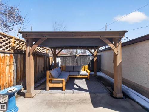 Covered patio area featuring a sturdy wooden pergola, concrete flooring, and privacy fencing - 11345 89 Street, Edmonton, AB - Outdoor With Deck Patio Veranda With Exterior