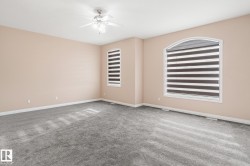 Spacious room featuring neutral-toned walls and gray carpeting - 