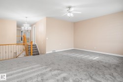 Spacious interior room with neutral-toned walls and plush gray carpeting - 