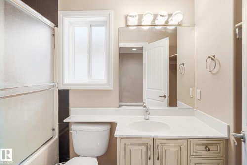 Bathroom featuring a vanity with an integrated sink, a large mirror, and a wall-mounted light fixture - 3455 29 Street, Edmonton, AB - Indoor Photo Showing Bathroom