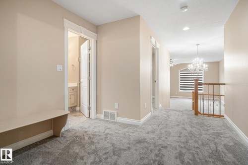 Upper-level hallway featuring plush gray carpeting, neutral wall tones, white trim, and a built-in bench - 3455 29 Street, Edmonton, AB - Indoor Photo Showing Other Room