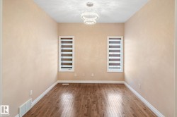 Recessed room featuring wood-finish flooring, light neutral walls, and white trim - 