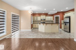 Open concept kitchen and living area featuring wood-finish flooring and tile flooring - 