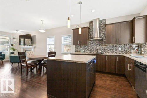Kitchen and dining area featuring dark wood-finish flooring - 575 Allard Boulevard, Edmonton, AB - Indoor Photo Showing Kitchen With Upgraded Kitchen