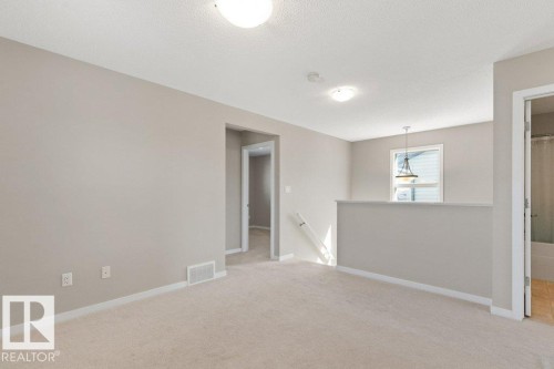 Upper-level landing featuring neutral carpeting, light neutral wall tones, and white trim - 575 Allard Boulevard, Edmonton, AB - Indoor Photo Showing Other Room