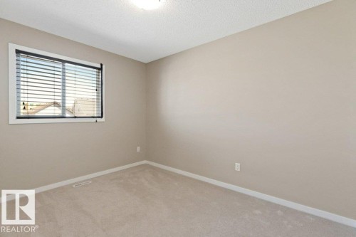Carpeted room with neutral paint, a single window featuring blinds, and a ceiling light fixture - 575 Allard Boulevard, Edmonton, AB - Indoor Photo Showing Other Room