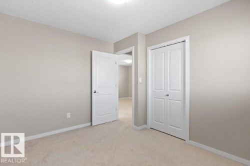 Neutral-toned room featuring light beige carpet flooring and white baseboards - 575 Allard Boulevard, Edmonton, AB - Indoor Photo Showing Other Room