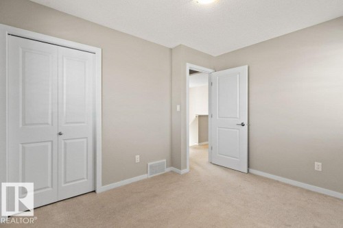 Bedroom featuring neutral-toned carpet flooring, light-colored wall paint, white trim, and a ceiling-mounted light fixture - 575 Allard Boulevard, Edmonton, AB - Indoor Photo Showing Other Room