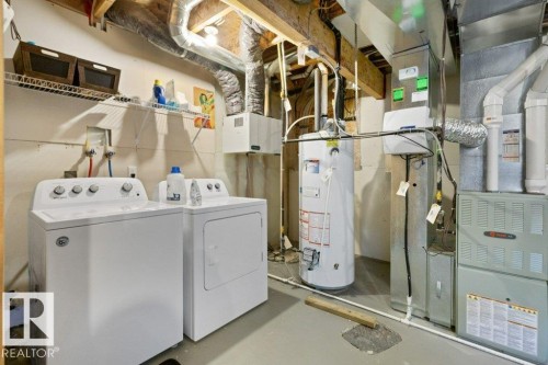 Basement utility area featuring exposed joists, ductwork, a water heater, and a furnace - 575 Allard Boulevard, Edmonton, AB - Indoor Photo Showing Laundry Room
