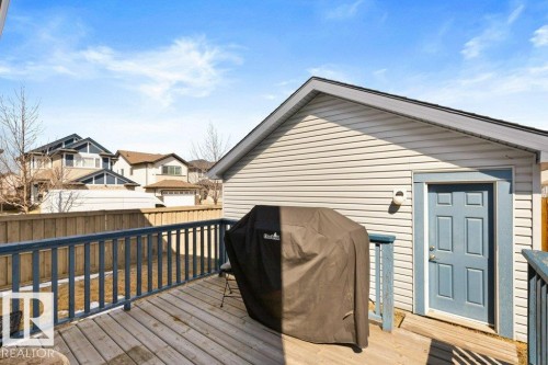 Wood-finish deck with blue railing, siding, and a blue paneled door - 575 Allard Boulevard, Edmonton, AB - Outdoor With Deck Patio Veranda With Exterior