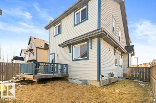 Rear exterior featuring light-toned horizontal siding with contrasting trim - 575 Allard Boulevard, Edmonton, AB - Outdoor With Deck Patio Veranda With Exterior