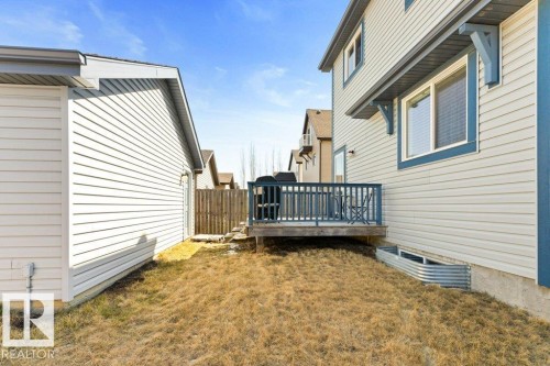 Rear exterior with an elevated wood deck featuring blue railings - 575 Allard Boulevard, Edmonton, AB - Outdoor With Deck Patio Veranda With Exterior