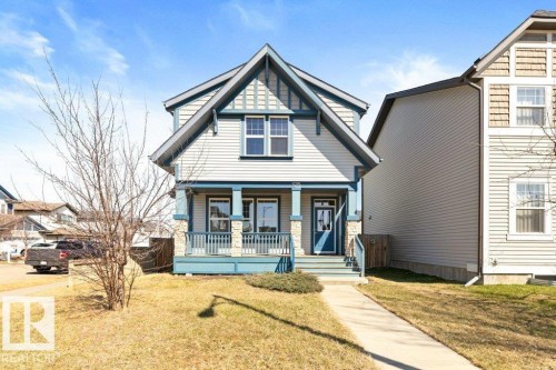 Cottage-style home featuring a prominent gabled roofline, light-toned siding, and stone accents - 575 Allard Boulevard, Edmonton, AB - Outdoor With Deck Patio Veranda
