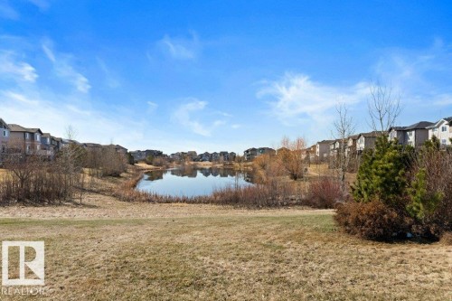 Pond-side properties featuring mature natural landscaping and a partially visible pathway - 575 Allard Boulevard, Edmonton, AB - Outdoor With View