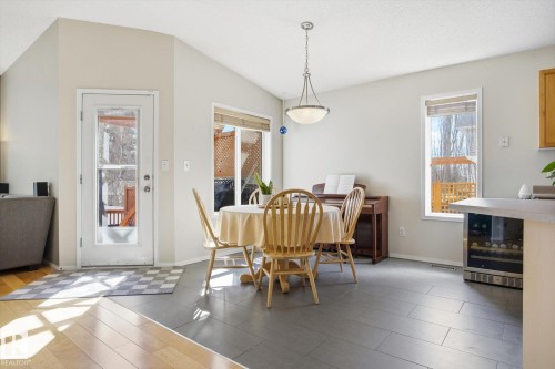 Vaulted ceilings highlight this dining area with grey tile flooring and a full-light exterior door - 2251 Brennan Court, Edmonton, AB - Indoor Photo Showing Dining Room