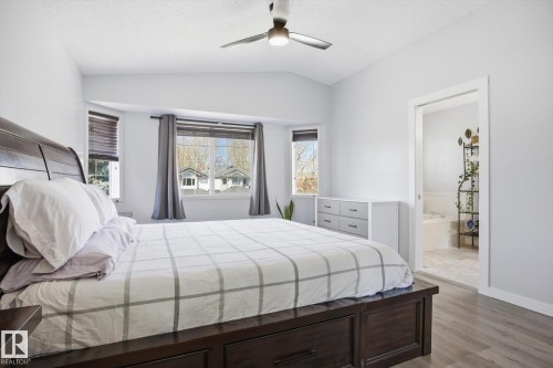 Light gray walls and wood-finish flooring complement a vaulted ceiling with a ceiling fan - 2251 Brennan Court, Edmonton, AB - Indoor Photo Showing Bedroom