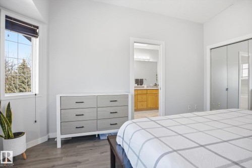 Spacious room featuring light-toned walls, wood-finish flooring, and a large window providing outdoor views - 2251 Brennan Court, Edmonton, AB - Indoor Photo Showing Bedroom