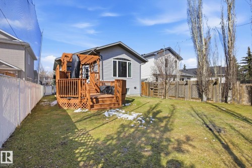 Expansive backyard featuring a multi-level wood deck with pergola, mature trees, and privacy fencing - 2251 Brennan Court, Edmonton, AB - Outdoor With Deck Patio Veranda