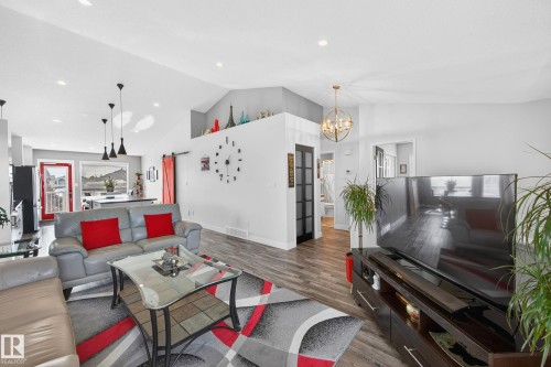 The living area features vaulted ceilings, recessed lighting, and wood-look flooring - 34 Donald Place, St. Albert, AB - Indoor Photo Showing Living Room
