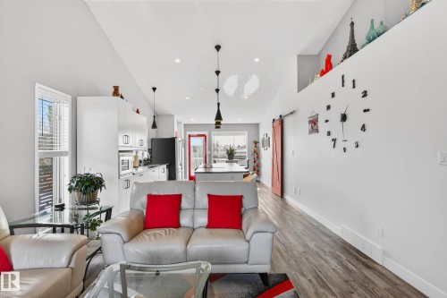 This open-concept living space features light-colored walls and wood-look flooring - 34 Donald Place, St. Albert, AB - Indoor Photo Showing Living Room