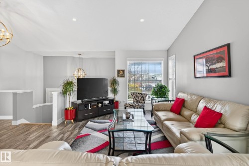 Living area featuring light gray walls, wood-style flooring, and a large window with blinds - 34 Donald Place, St. Albert, AB - Indoor Photo Showing Living Room