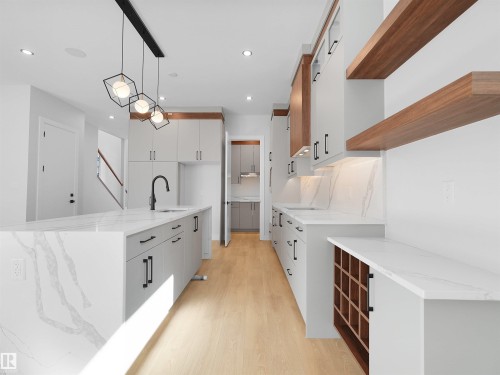 Modern kitchen featuring light wood-finish flooring and a central island with a waterfall countertop - 6722 Crawford Way, Edmonton, AB - Indoor