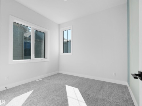Carpeted room featuring white walls, white trim, and two windows with white frames - 6722 Crawford Way, Edmonton, AB - Indoor Photo Showing Other Room