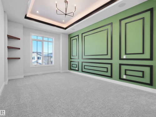 Spacious room featuring a green accent wall with black decorative trim - 6722 Crawford Way, Edmonton, AB - Indoor Photo Showing Other Room