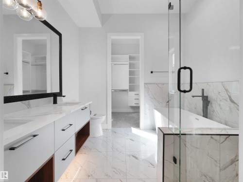 Contemporary bathroom featuring a freestanding tub with a wall-mounted faucet, a frameless glass shower enclosure, and a double vanity with undermount sinks - 6722 Crawford Way, Edmonton, AB - Indoor Photo Showing Bathroom