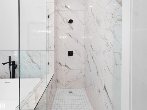 Walk-in shower with full-height veined tile surround, matte black shower fixtures, and a glass enclosure - 6722 Crawford Way, Edmonton, AB - Indoor Photo Showing Bathroom
