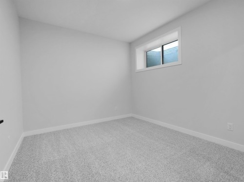 Carpeted room featuring light gray walls, white trim, and a horizontal sliding window - 6722 Crawford Way, Edmonton, AB - Indoor Photo Showing Other Room