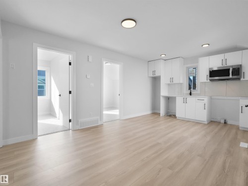 Open-concept space featuring light wood-finish flooring, white walls, and recessed lighting - 6722 Crawford Way, Edmonton, AB - Indoor Photo Showing Kitchen