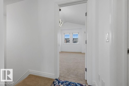 Carpeted room with vaulted ceilings, multiple windows, and a modern ceiling light fixture - Edmonton, AB - Indoor Photo Showing Other Room