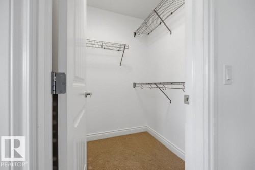 Walk-in closet featuring light beige carpet, white baseboards, and white walls - Edmonton, AB - Indoor With Storage