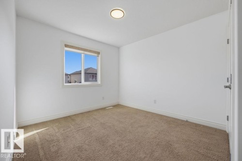 Bright interior room with neutral carpeting and white baseboards - Edmonton, AB - Indoor Photo Showing Other Room