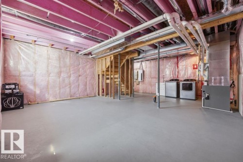Unfinished basement featuring exposed wood beams, concrete flooring, and utility infrastructure - Edmonton, AB - Indoor Photo Showing Basement
