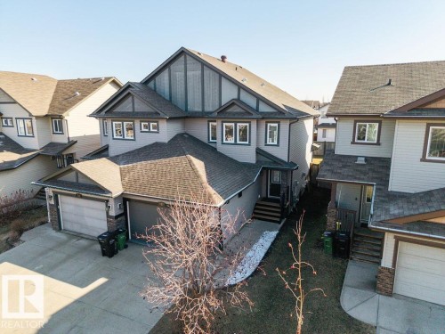 Contemporary two-story home featuring light gray siding and dark trim accents - Edmonton, AB - Outdoor With Facade