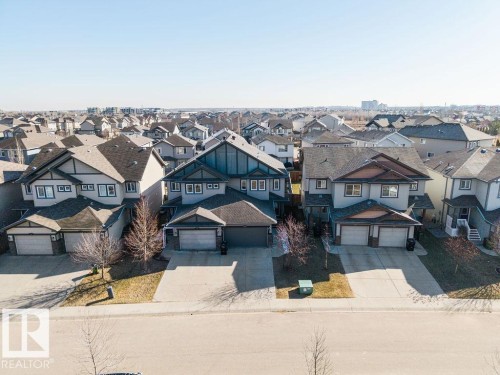 Contemporary suburban residence featuring a two-car garage, concrete driveway, and a combination of siding and stone exterior finishes - Edmonton, AB - Outdoor With Facade